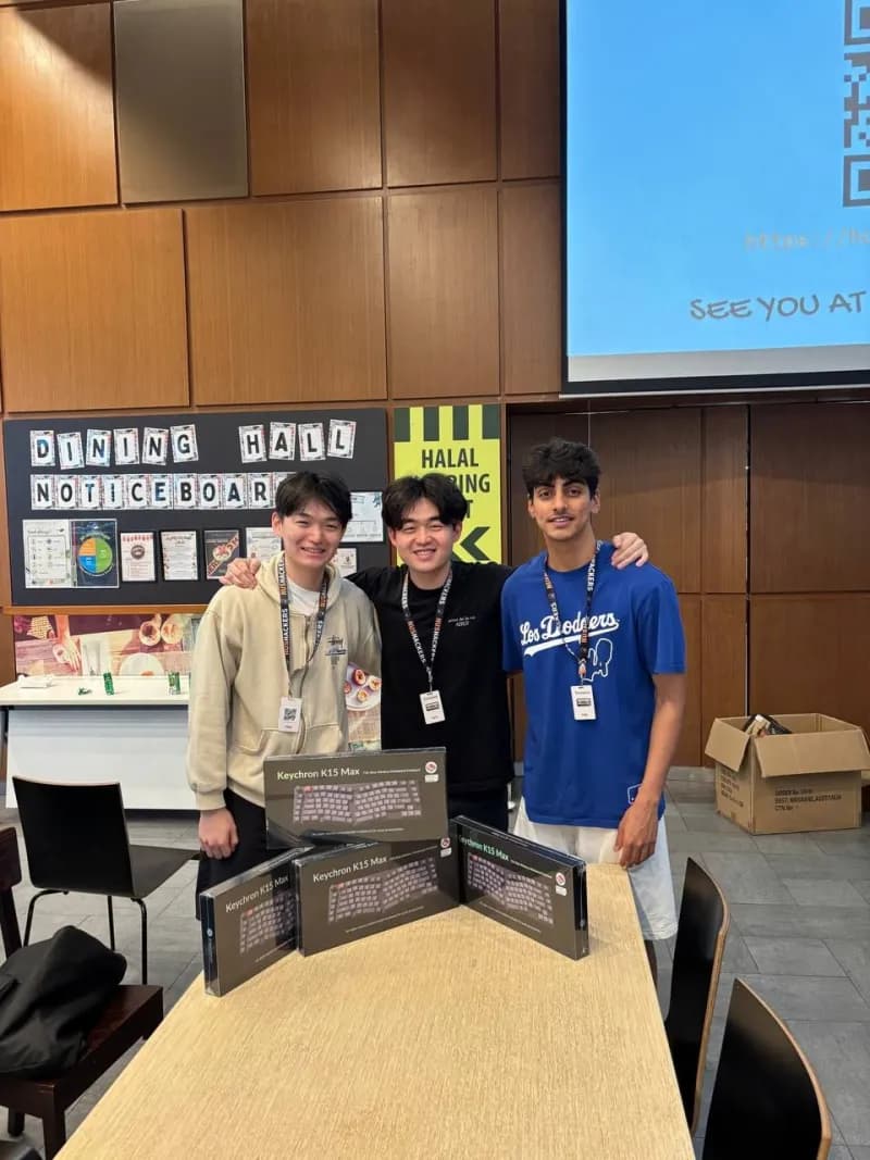 Two teammates holding the keyboards they won.